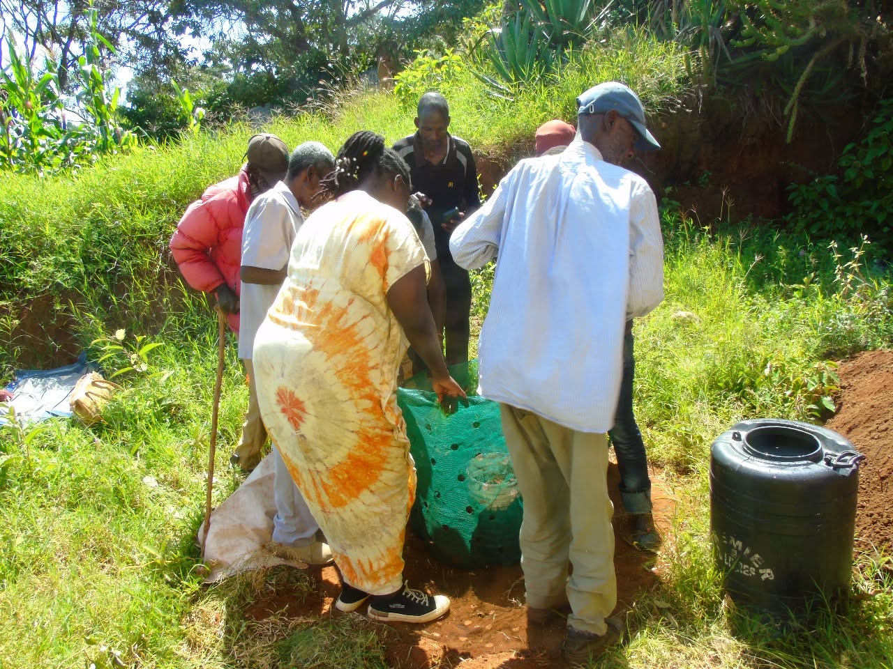 A group filling a sack garden with soil during kitchen gardening training