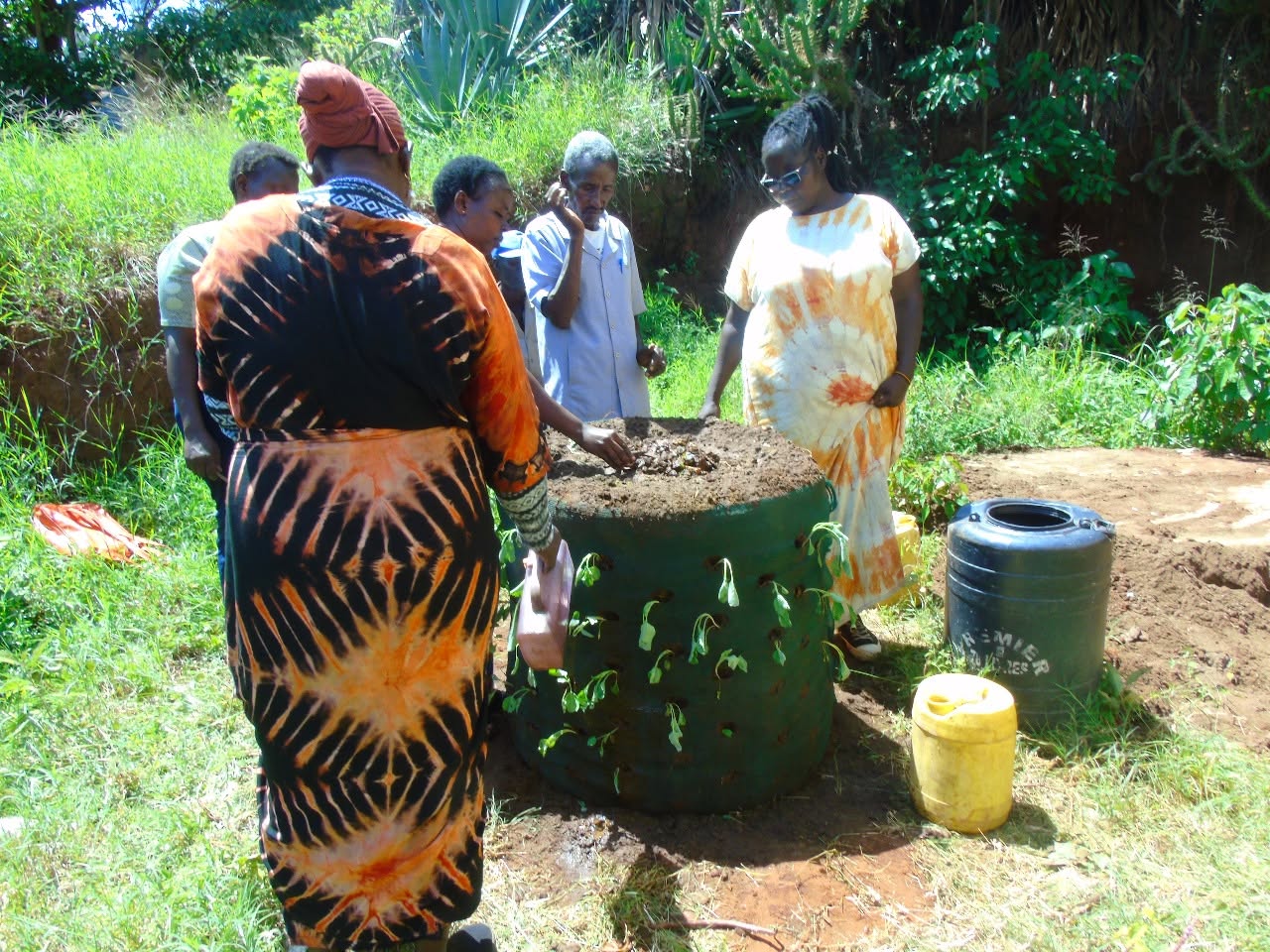 Participants planting seedlings into the sides of a sack garden