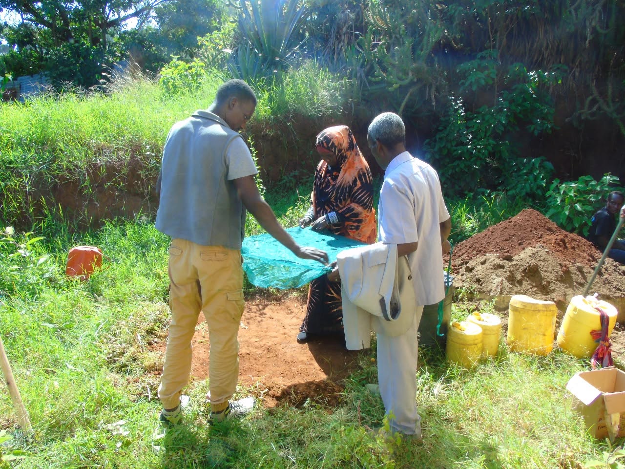 Participants laying out green netting for a sack garden