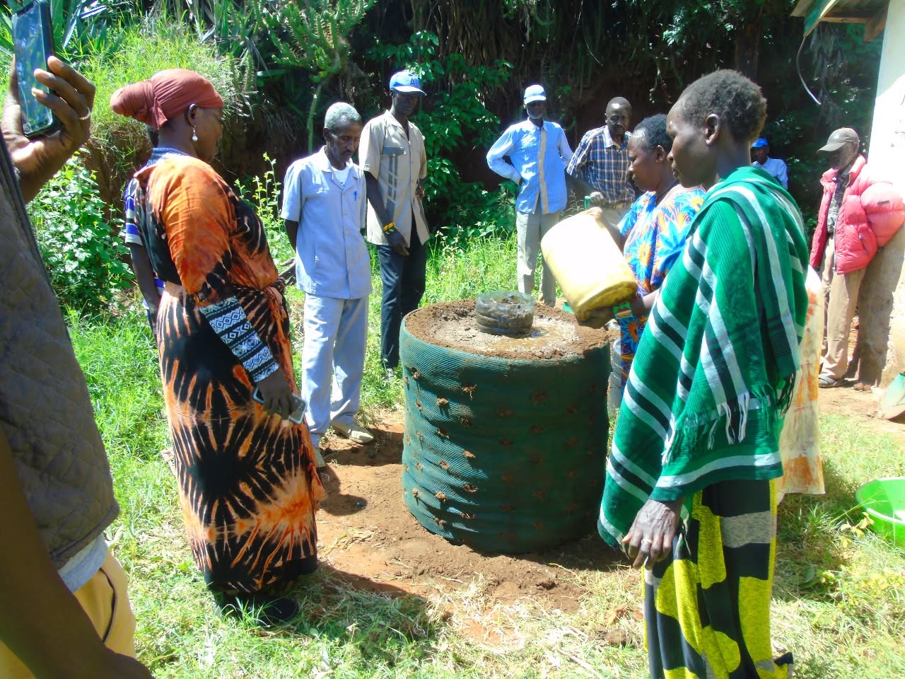 Women watering a newly planted sack garden during kitchen gardening training